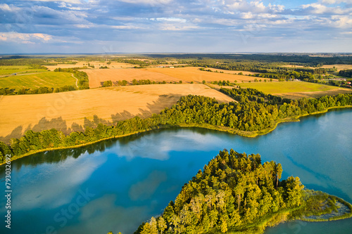 A landscape with yellow fields and a blue lake. Classic European farmlands