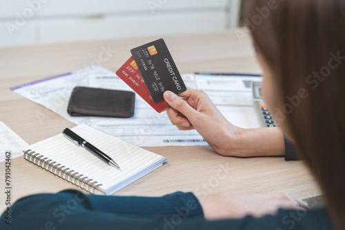 Business financial concept, stressed asian young business woman hand holding credit card for calculate accounting expense of bill, tax for payment on due deadline, trying to find money to pay debt.
