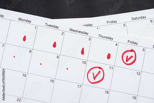 Hand draws red drops on the calendar, then places a red checkmark in a circle - concept of menstrual cycle tracking, ovulation, and pregnancy planning