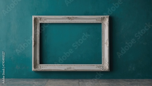 Empty white frame leans on an aegean teal painted wall