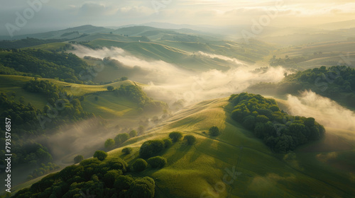 Aerial view of rolling hills bathed in the soft morning light with mist weaving through the valleys