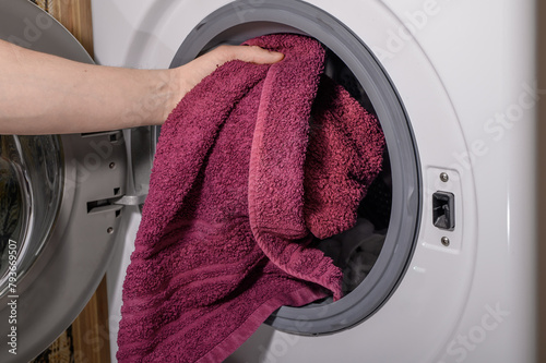 Robić pranie, wkładać ubrania i ręczniki do bębna pralki