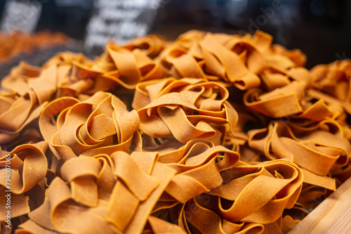 Italian food, dried handmade colorful pasta pappardelle with saffron, ready to cook, Milan, Lombardy, Italy