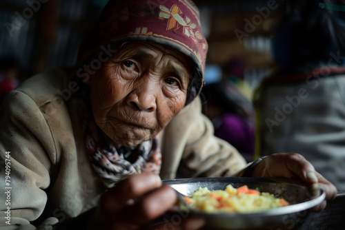Portrait of a homeless elderly woman with a plate of food at the shelter. Shallow depth of field