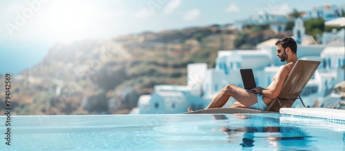 man working with laptop in swimming pool in summer