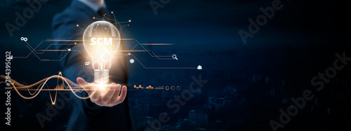 SCM: Businessman holding creative light bulb with Digital networking and SCM icon. Supply Chain Management, Logistics Optimization, Strategic Collaboration, on blue city background.