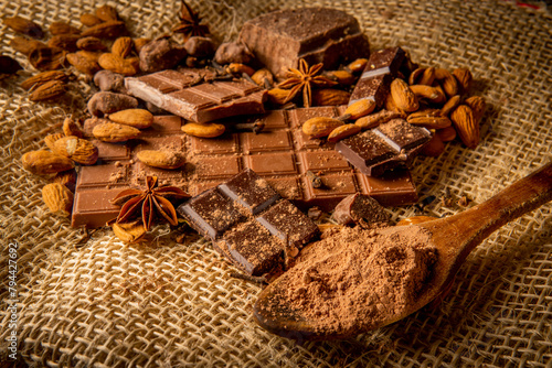 Still life of different types of chocolate with almonds and spices
