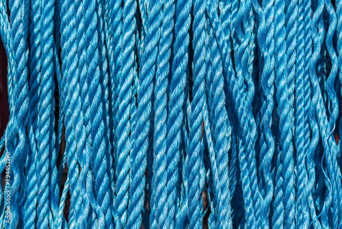 background close up of industrial blue ropes hanging vertically 