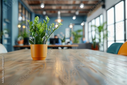 An orange potted plant stands out on a wooden table in the vivid, bustling atmosphere of an office cafeteria