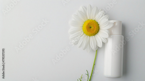 Deodorant and chamomile flower on white background