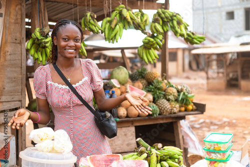 Young Black African Saleswoman Presenting Fresh Fruits at Local Fruit Stand