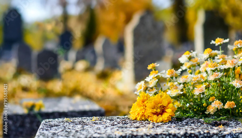 A cemetery with a grave site with a flower arrangement. The flowers are yellow and white