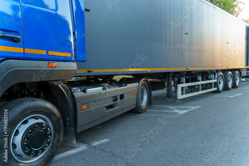 A new truck with a trailer on the road. Details of the truck in close-up. New headlights and wheels of the car. The concept of cargo transportation