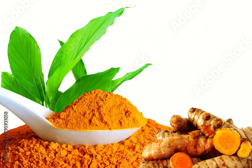 turmeric or curcumin longa root powder in spoon with leaves known in india as haldi,huldi,haldar,isolated on white background