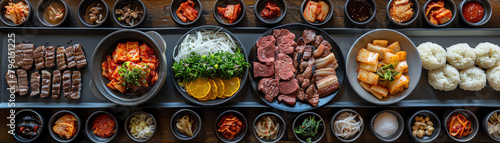 A South Korean BBQ setup with marinated meats, kimchi, and various banchan, arranged on a modern dining table
