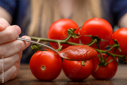 Zdrowy domowy ketchup, przecier pomidorowy na łyżeczce obok świeże pomidory