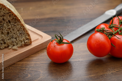 Dojrzałe czerwone pomidory malinowe obok chleba na kanapki, jedzenie na surowo 