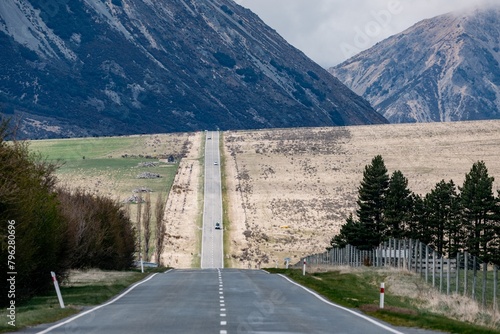 Long country road with cars driving on it at Arthur's Pass, Canterbury, New Zealand.