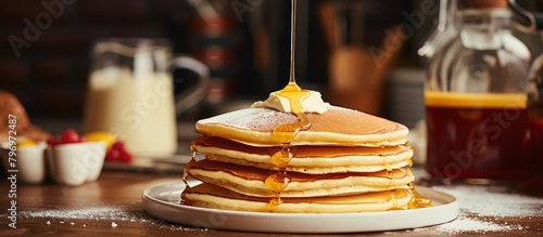 Stack of delicious pancakes topped with butter and syrup