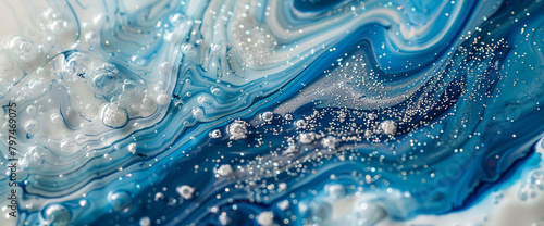 Celestial azure marble ink cascades elegantly through a radiant abstract scene, speckled with sparkling glitters.