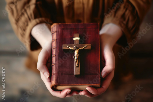 Devote Christian woman with faith holding a holy bible with a crucifix from directly above 