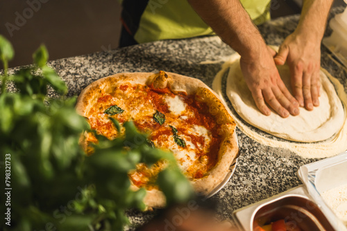 Man working in restaurant kitchen preparing traditional pizza. High quality photo