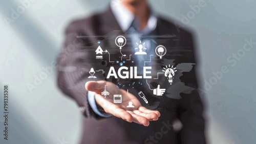 Agile Methodology Visualization: Businessperson with hand outstretched towards the camera, showcasing "AGILE" encircled by icons representing teamwork and innovation.