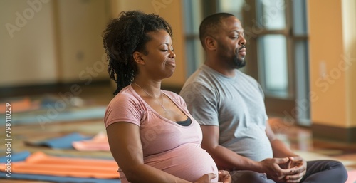 A man and woman attending a prenatal class, practicing breathing techniques together
