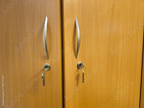 drzwi szafki zamknięte na klucze i klucze wiszące w zamku