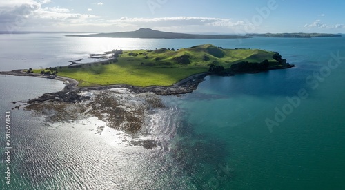 The volcano and crater of Browns Island in the Waitamata Harbour. In the background is Rangitoto Island. Auckland, Auckland, New Zealand.