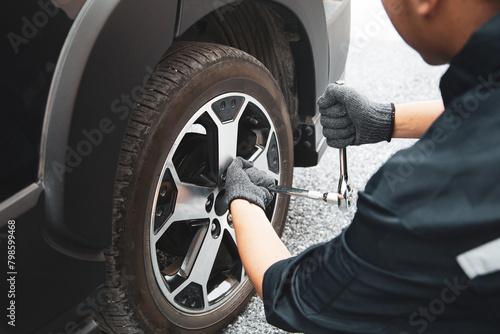 Auto mechanic use wrench to repairing and change car tires. Concept of car care service and maintenance or fix the car leaky or flat tire.