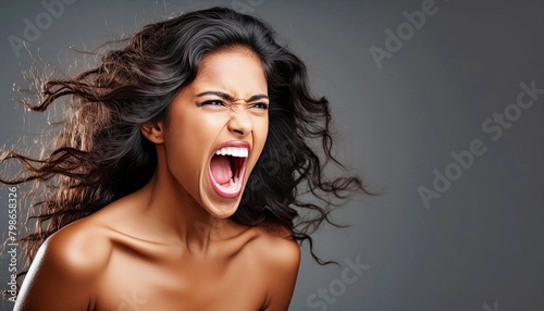 On dark copy space background, angry furious mad woman screaming with extreme rage, full of fury or violent passion