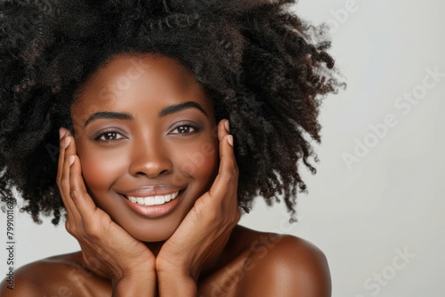 A studio portrait of a lady with a natural, health, or cosmetic face routine. An African female model with facial dermatology on a gray backdrop is healthy and young.