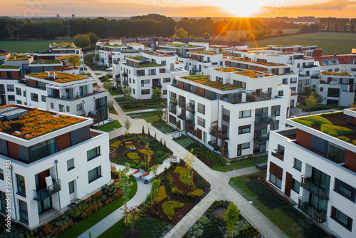 Eco-friendly roofs and landscaped courtyards shine in a noon aerial view of a European apartment complex, highlighting sustainability.