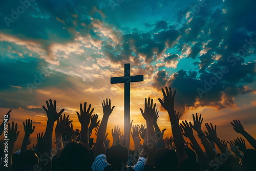 People raising hands in front of a huge cross during sunset