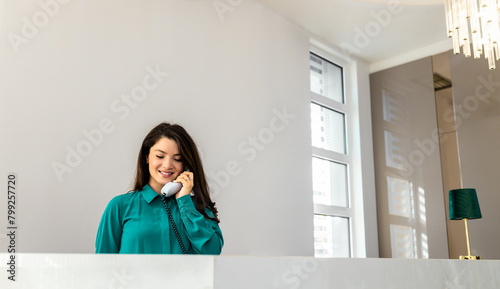 Friendly administrator assisting woman at reception desk