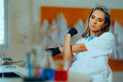 Tired Scientist Stretching her Arms Working in the Lab. Sad overworked research worker trying to meet deadline for a project 