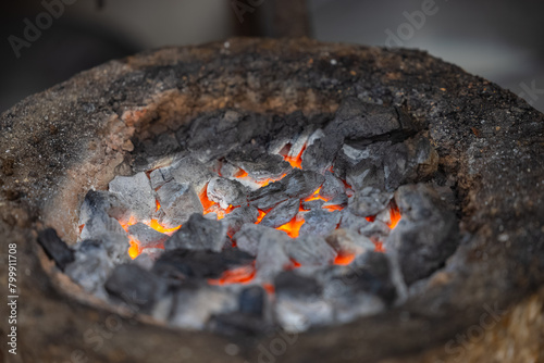 Burning coal on mud stove or chulha at tea shop.
