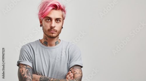 Portrait of a young man with pink hair and multiple tattoos looking seriously at the camera.