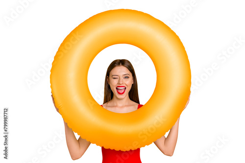 Beach style! Travel daydream concept. Positive girl look through colorful rubber rings enjoying rest isolated on yellow background