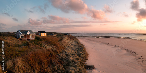 Aerial view of remote beach huts on the Northumberland coast at Embleton Bay beach at sunrise
