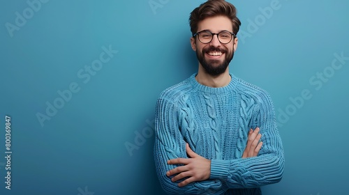 A Young handsome man with beard wearing casual sweater and glasses over blue background with hands together and crossed fingers smiling relaxed and cheerful, Success and optimistic