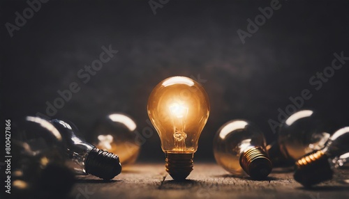  One of Lightbulb glowing among shutdown light bulb in dark area with copy space for creative thinking , problem solving solution and outstanding concept 