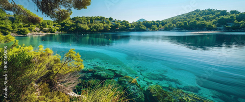 A tranquil teal-colored bay surrounded by lush greenery, its calm waters reflecting the serenity of the landscape.