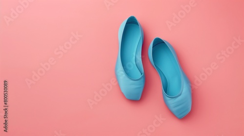 Flat solid color illustration of a pair of cerulean blue ballet slippers on a soft pink background.