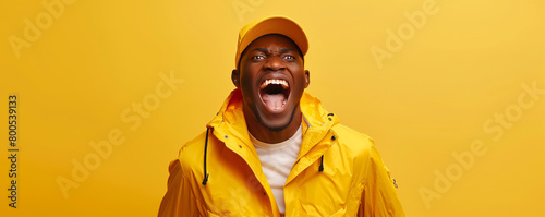 Joyful man laughing in yellow outfit against a yellow background