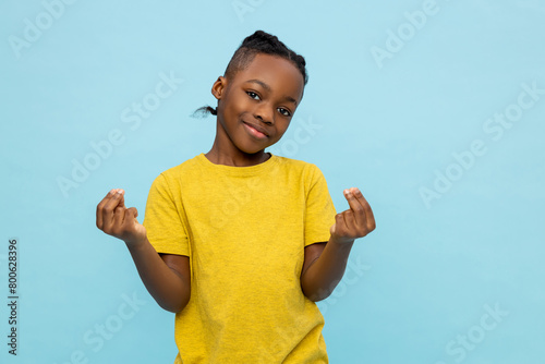 Boy in yellow tshirt standing on blue background and gesticulating