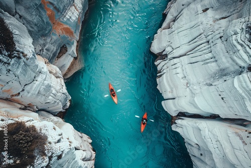 A drone shot of two kayakers in the middle of a turquoise