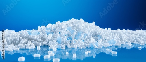An array of plastic pellets on a vibrant blue background, emphasizing the issue of plastic production waste,