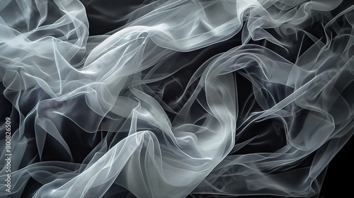 A high-contrast image depicting a delicate white sheer fabric that glistens and flows gracefully over a dark background